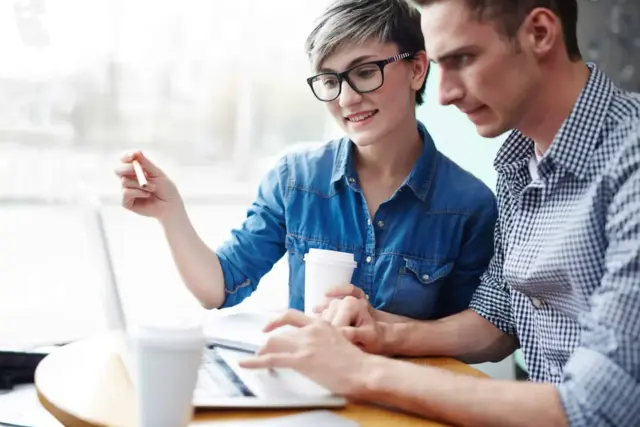Two people collaborating over a laptop